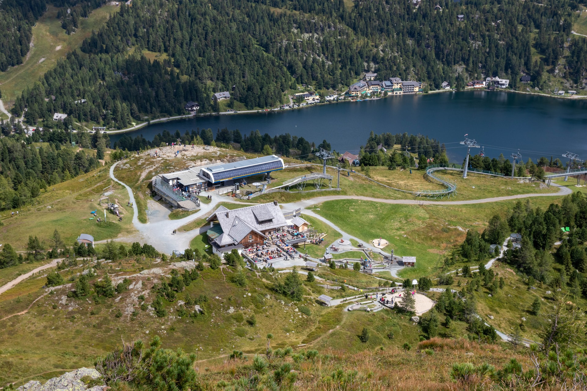 Aerial view of mountains and a lake with tourism infrastructure.